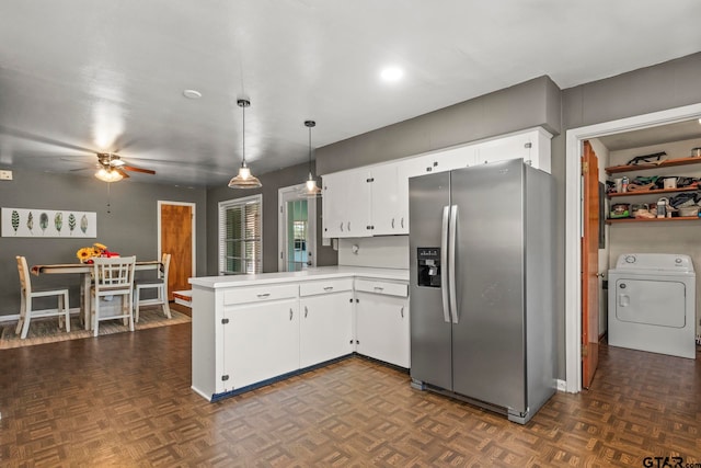 kitchen with kitchen peninsula, washer / clothes dryer, hanging light fixtures, white cabinets, and stainless steel fridge