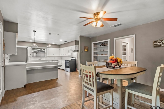 dining room featuring ceiling fan, sink, and dark parquet floors