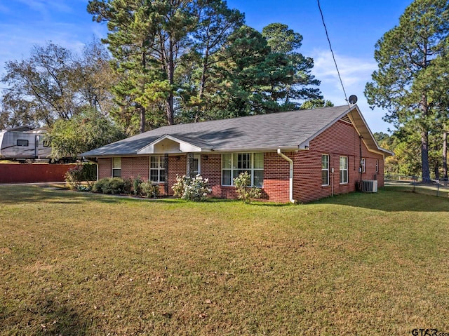 ranch-style house with cooling unit and a front yard