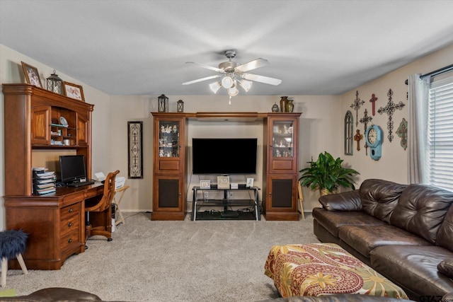 living area featuring baseboards, a ceiling fan, and light carpet