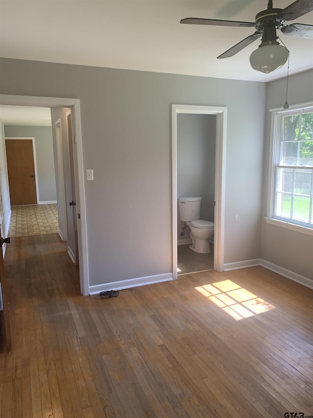 2326 Pleasant Dr, Tyler, TX 75701 - unfurnished bedroom featuring dark wood finished floors, connected bathroom, and a ceiling fan