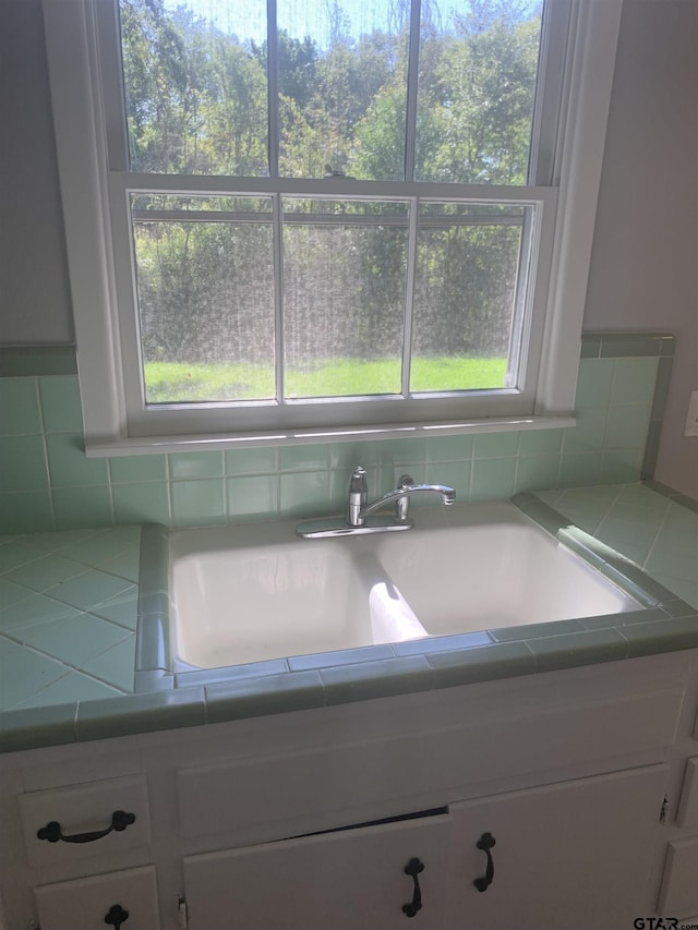2326 Pleasant Dr, Tyler, TX 75701 - kitchen with white cabinets, tile countertops, and tasteful backsplash
