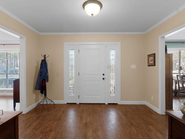 foyer entrance with ornamental molding and dark wood-type flooring