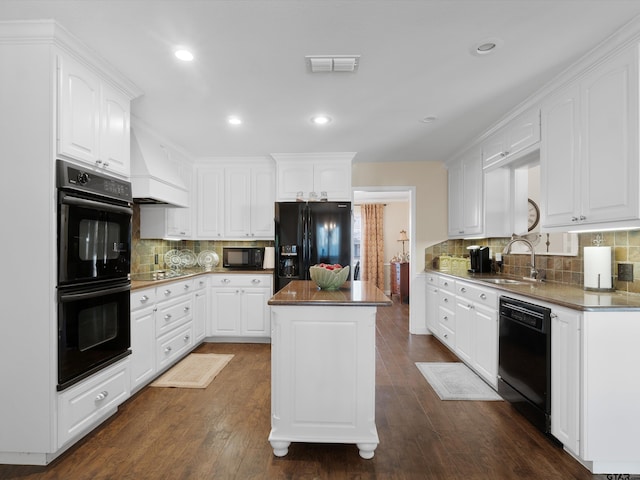 kitchen with premium range hood, white cabinets, a kitchen island, and black appliances