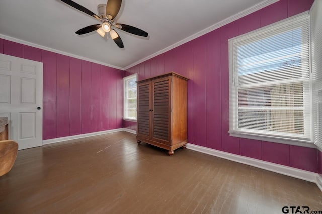 unfurnished bedroom with ceiling fan, baseboards, crown molding, and wood finished floors