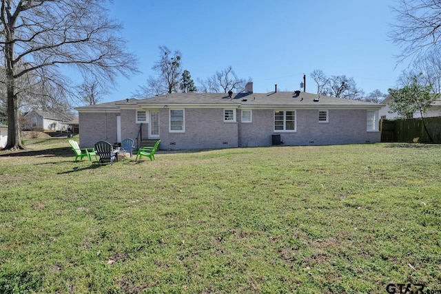 back of property with brick siding, a yard, a chimney, crawl space, and central AC