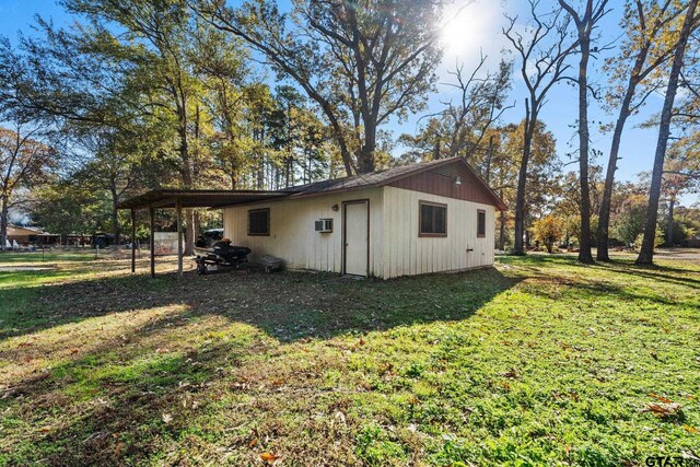 view of outbuilding with a carport and a lawn