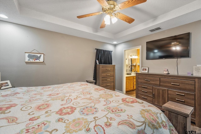 119 Vz County Road 4833, Chandler, TX 75758 - bedroom featuring connected bathroom, visible vents, a ceiling fan, and a raised ceiling