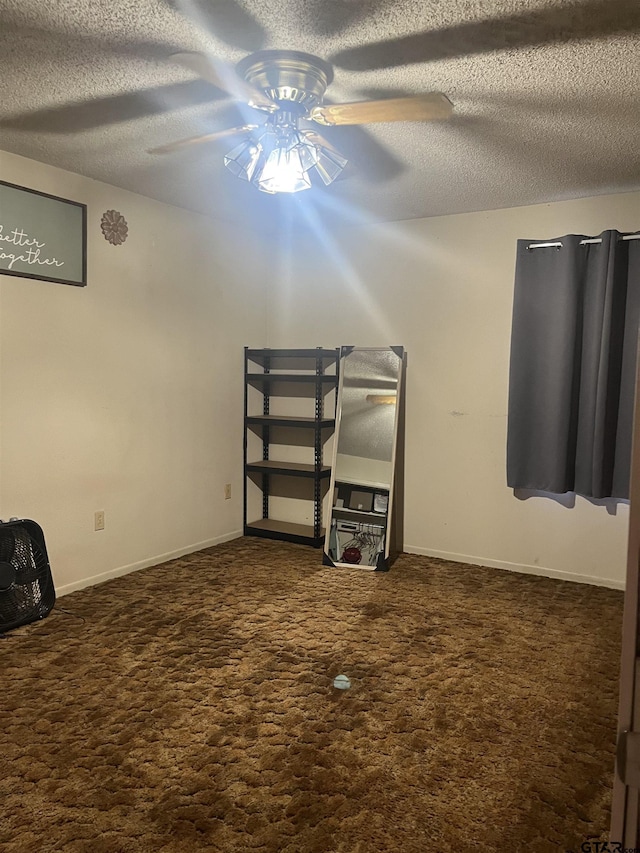 unfurnished bedroom featuring baseboards, a ceiling fan, a textured ceiling, and carpet