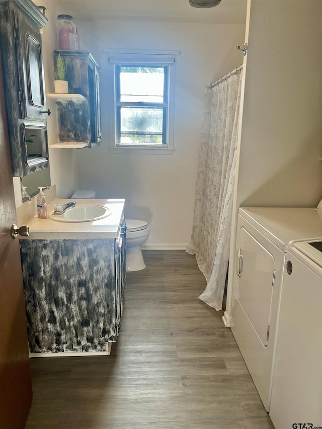 bathroom with wood finished floors, toilet, vanity, baseboards, and washer and clothes dryer