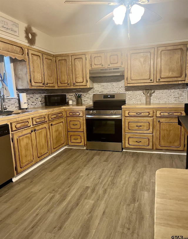 kitchen featuring under cabinet range hood, decorative backsplash, ceiling fan, light countertops, and appliances with stainless steel finishes