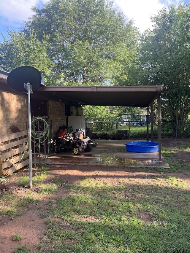 view of yard with a carport and fence
