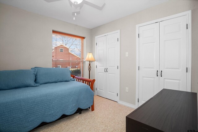 160 Lookout Point Dr, Grapeland, TX 75844 - bedroom featuring light colored carpet, ceiling fan, baseboards, and two closets