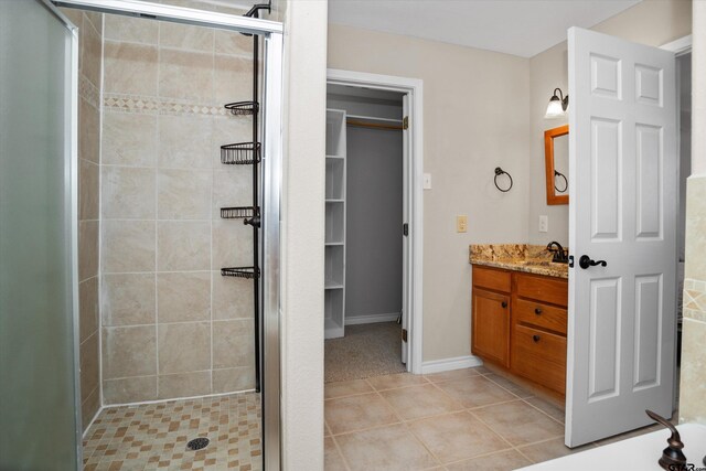 160 Lookout Point Dr, Grapeland, TX 75844 - bathroom with baseboards, tile patterned floors, a walk in closet, vanity, and a shower stall