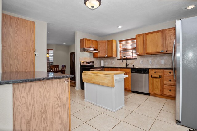 160 Lookout Point Dr, Grapeland, TX 75844 - kitchen with under cabinet range hood, light tile patterned floors, stainless steel appliances, and backsplash