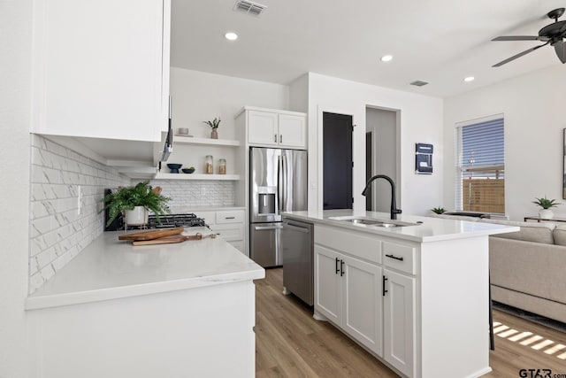kitchen featuring visible vents, a ceiling fan, white cabinets, a sink, and stainless steel appliances