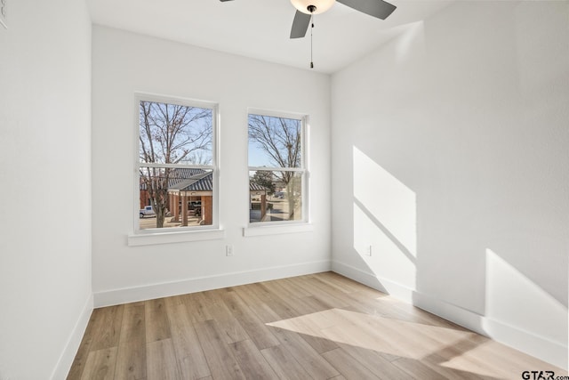 spare room featuring a ceiling fan, baseboards, and light wood-style floors