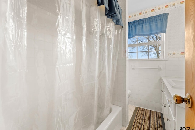 bathroom with shower / tub combo, tile walls, and vanity