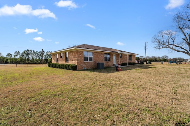 back of property with a yard and central AC unit