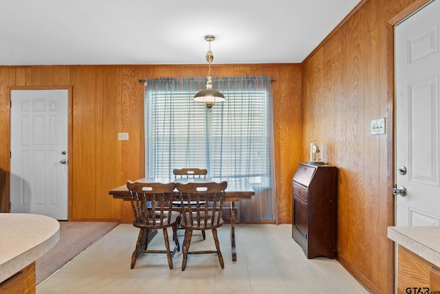 dining space featuring wood walls