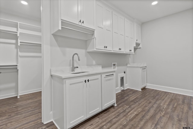 laundry area featuring sink, dark wood-type flooring, electric dryer hookup, cabinets, and washer hookup