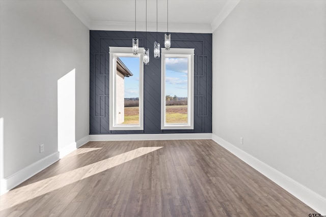 unfurnished dining area featuring hardwood / wood-style flooring, ornamental molding, and a chandelier