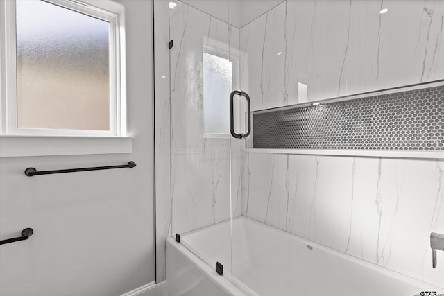 bathroom with shower / bath combination with glass door