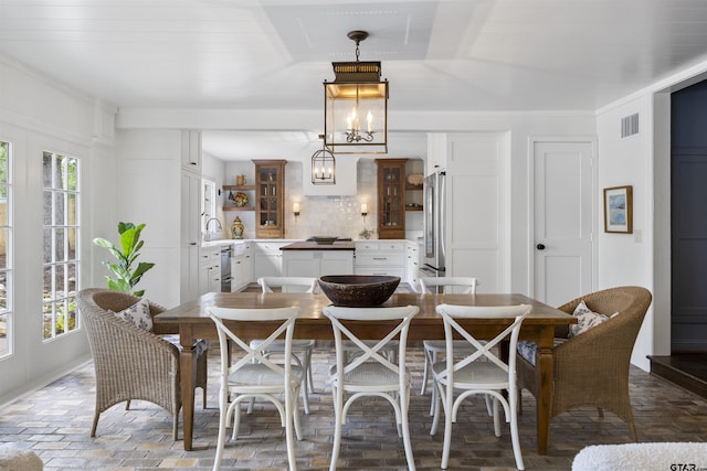2417 Old Bullard Rd, Tyler, TX 75701 - dining space featuring plenty of natural light, brick flooring, and a chandelier