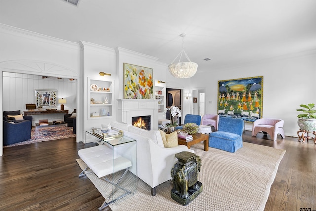 2417 Old Bullard Rd, Tyler, TX 75701 - living room featuring ornamental molding, a chandelier, a warm lit fireplace, and wood finished floors