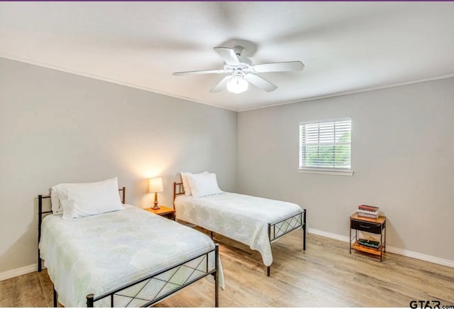 bedroom with ornamental molding, ceiling fan, and light hardwood / wood-style flooring