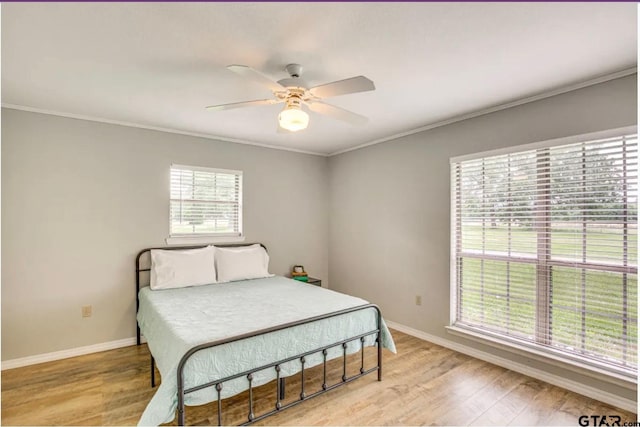 bedroom with ornamental molding, ceiling fan, and light hardwood / wood-style floors