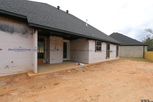 rear view of property with a patio area and a shingled roof