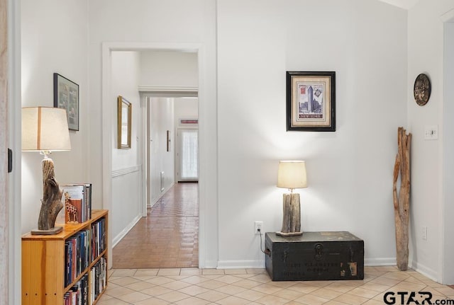 hallway featuring light tile patterned floors and baseboards