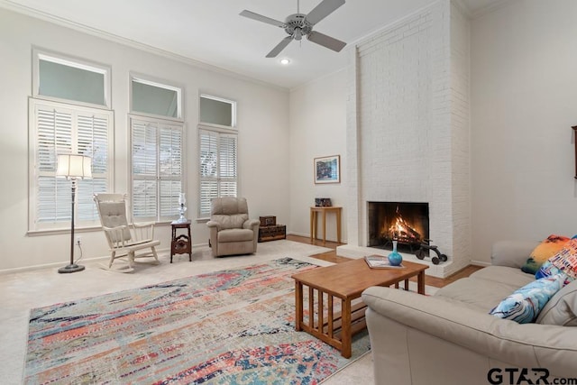 living room with baseboards, light colored carpet, ceiling fan, crown molding, and a fireplace