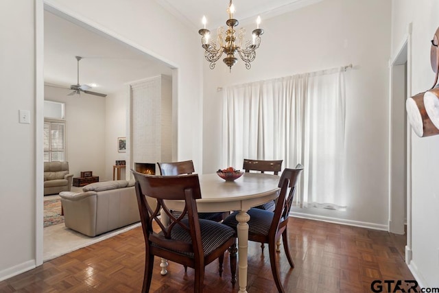 dining room with crown molding, ceiling fan with notable chandelier, and baseboards