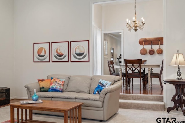 living area featuring an inviting chandelier, baseboards, and crown molding