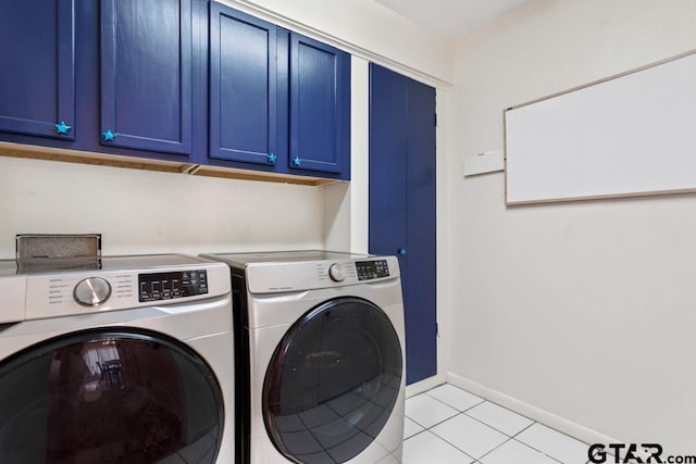 laundry area with cabinet space, light tile patterned floors, baseboards, and washer and clothes dryer