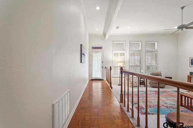 corridor featuring plenty of natural light, visible vents, beamed ceiling, and baseboards