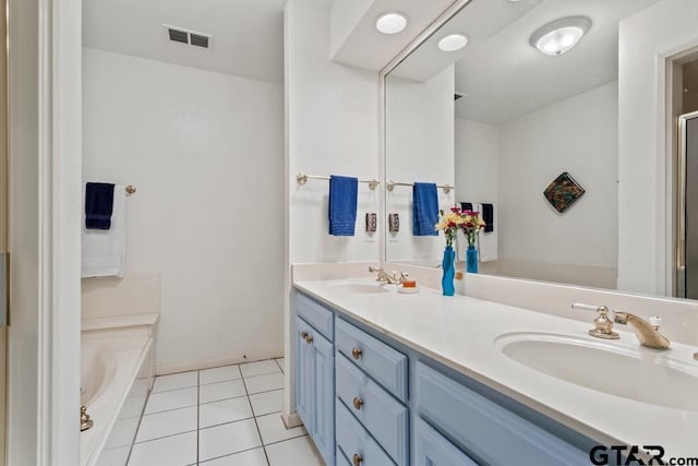 bathroom with a garden tub, double vanity, visible vents, a sink, and tile patterned flooring