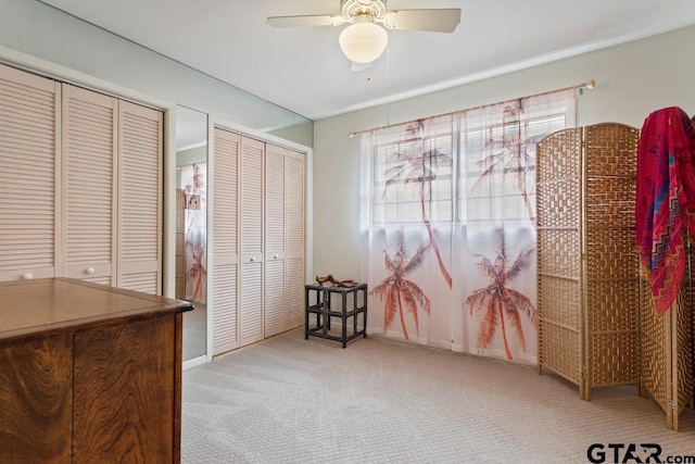 interior space with ceiling fan and multiple closets