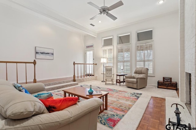 living room with ornamental molding, plenty of natural light, a fireplace, and visible vents