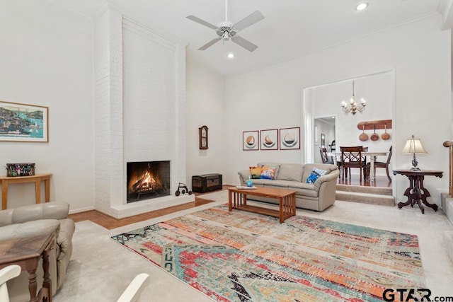 living room with baseboards, ceiling fan, ornamental molding, a brick fireplace, and recessed lighting