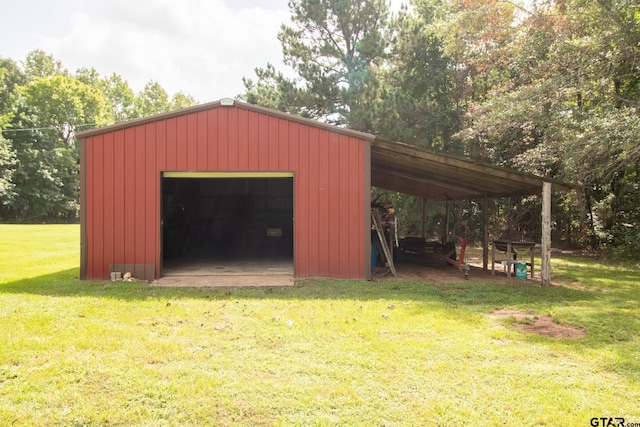 view of outbuilding featuring a carport, a garage, and a yard