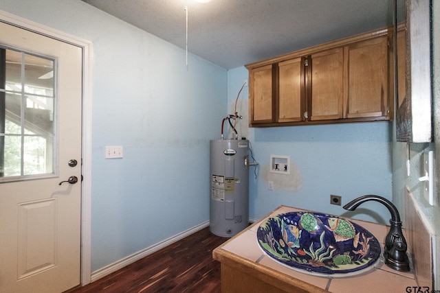 washroom with hookup for an electric dryer, hookup for a washing machine, sink, water heater, and dark hardwood / wood-style floors