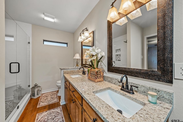 411 Raton, Holly Lake Ranch, TX 75765 - bathroom with toilet, wood finished floors, double vanity, a stall shower, and baseboards