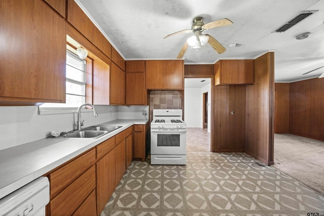 kitchen featuring visible vents, a sink, brown cabinets, and white appliances