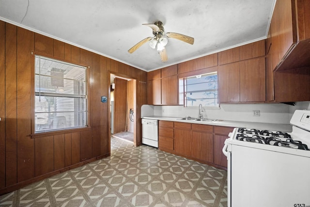 kitchen featuring light countertops, a sink, light floors, brown cabinets, and white appliances