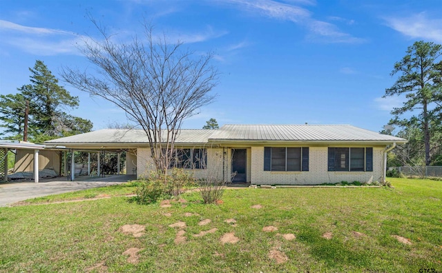 ranch-style home featuring metal roof, an attached carport, brick siding, a front lawn, and driveway
