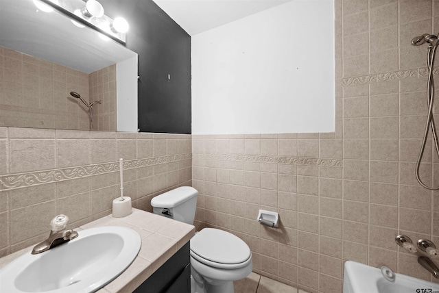 bathroom with tile patterned floors, toilet, vanity, tub / shower combination, and tile walls