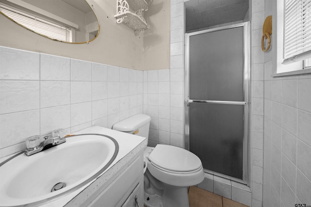 bathroom with tile walls, a stall shower, and vanity